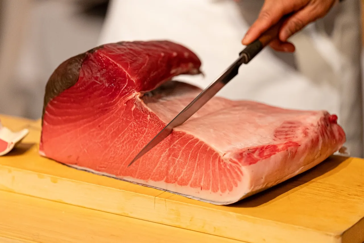 マグロの柵を包丁で切り分ける様子